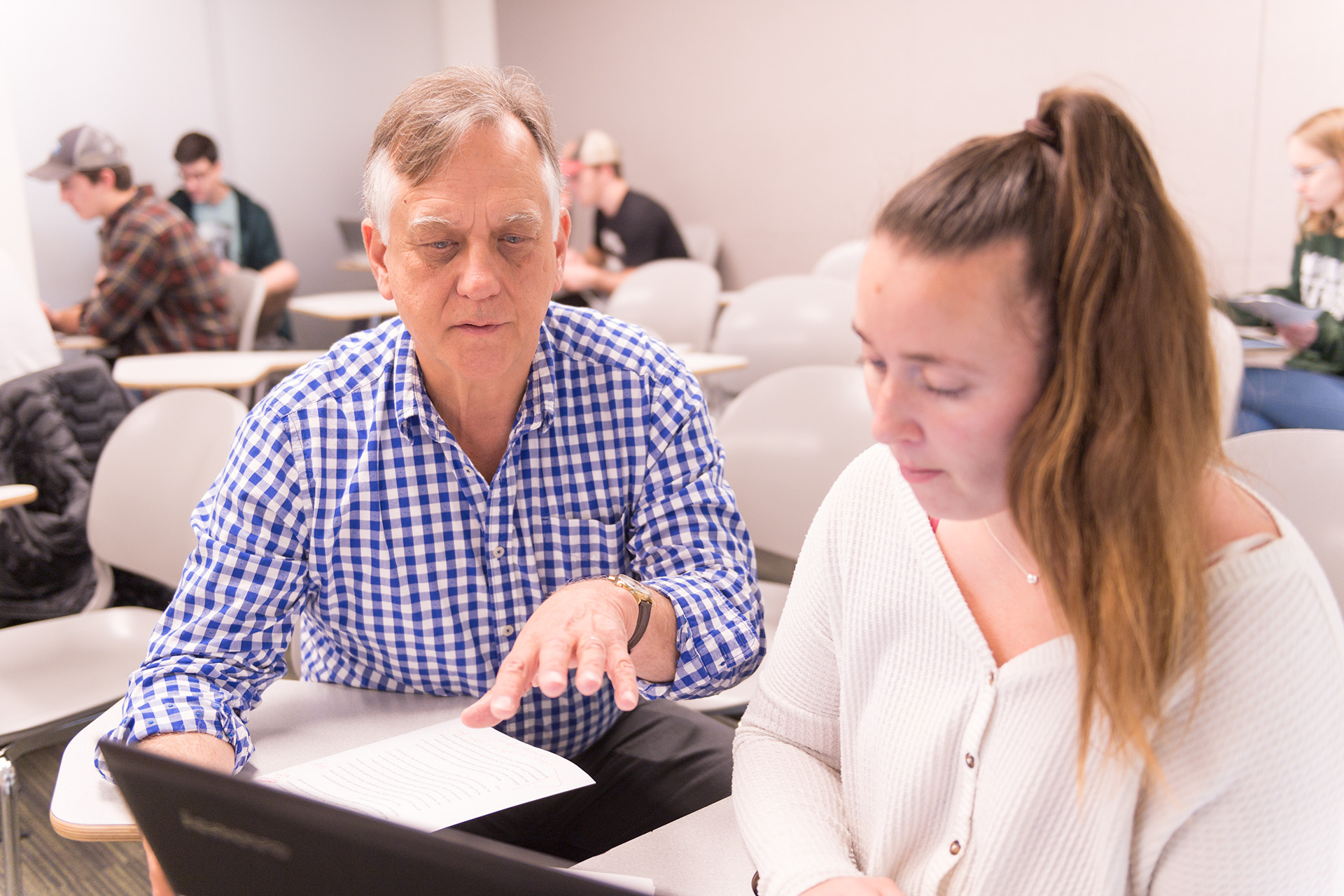 Colorado State University Economics professor Ed Barbier talks with a student in a capstone class about her project, May 2, 2019.