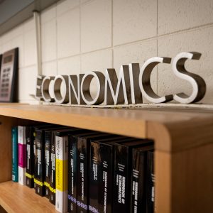 Letters on top of bookshelf that spell "Economics"