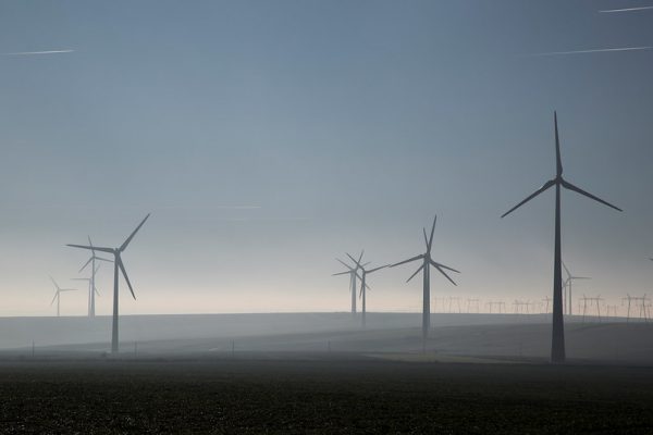 A cloudy skyline dotted with wind turbines.